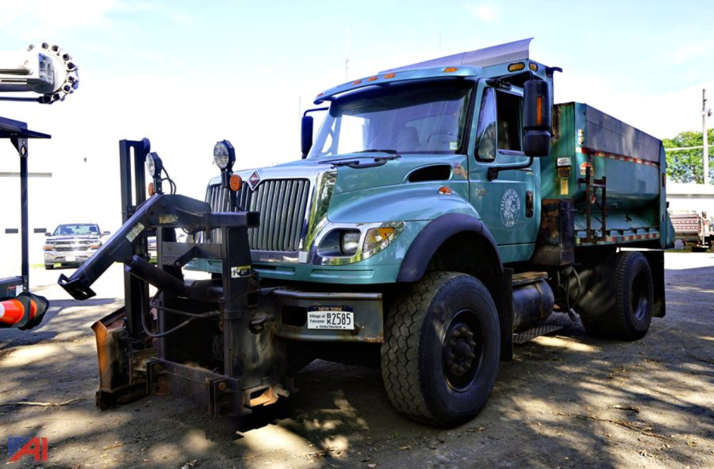 Heavy-duty dump truck with plow attachment on front, teal cab, black chassis, and green dump bed, International WorkStar 7600 series, VIN 1HTTXAHR14J022805