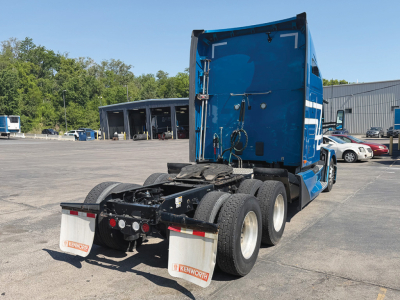 Kenworth T680 Next Gen rear view showing chassis and dual rear axles in blue cab with white accents.