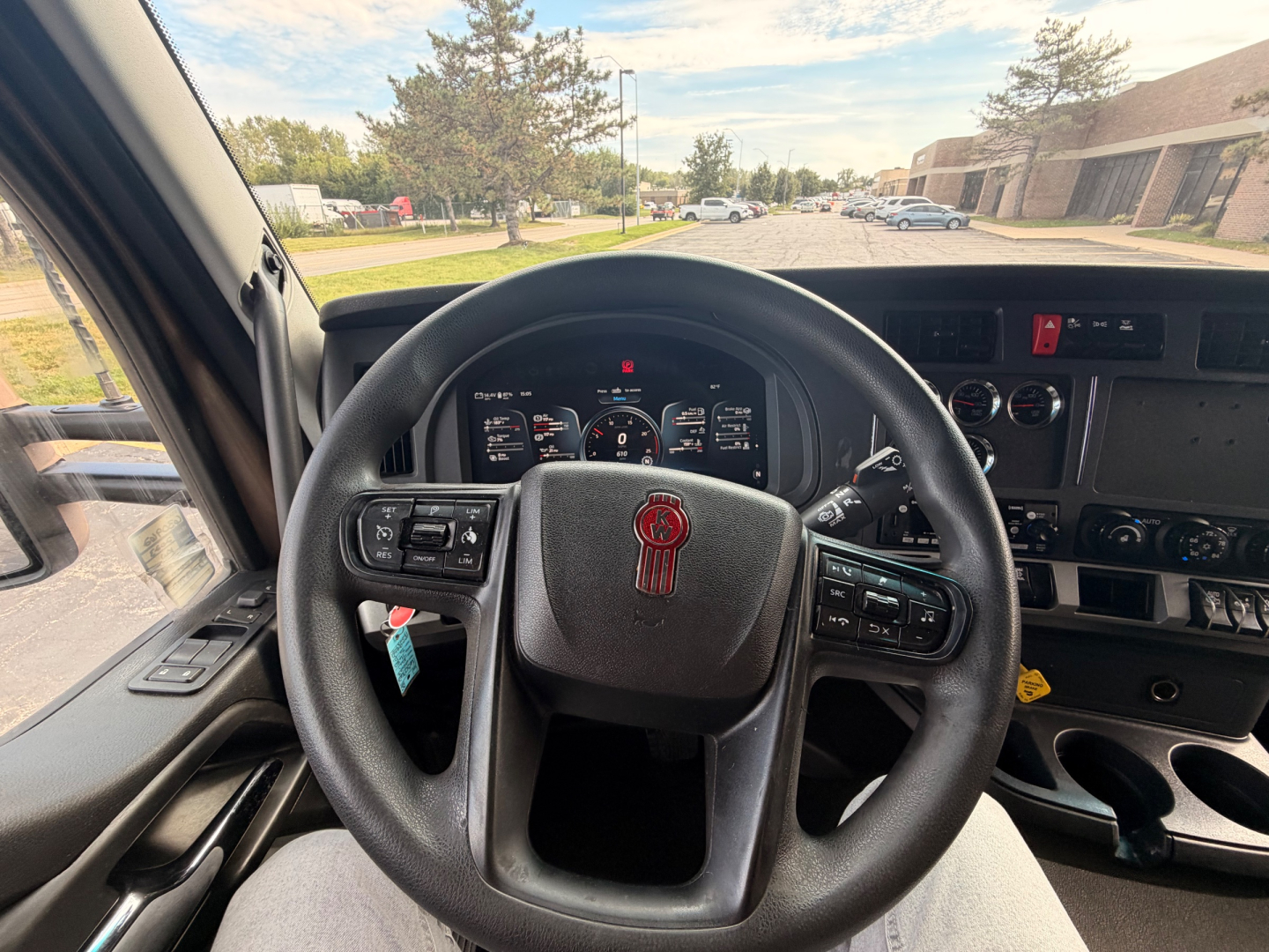 Kenworth T680 steering wheel and dashboard view from driver seat in truck cab showing controls and gauges.