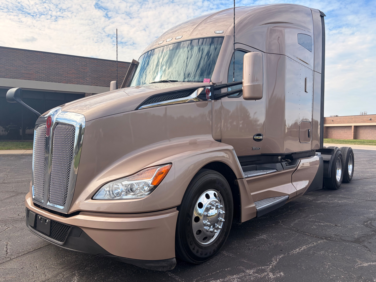 Kenworth T680 tractor in a beige color, front and side view, showing chrome grille, headlights, and dual rear axles. VIN and stock number not visible in image.