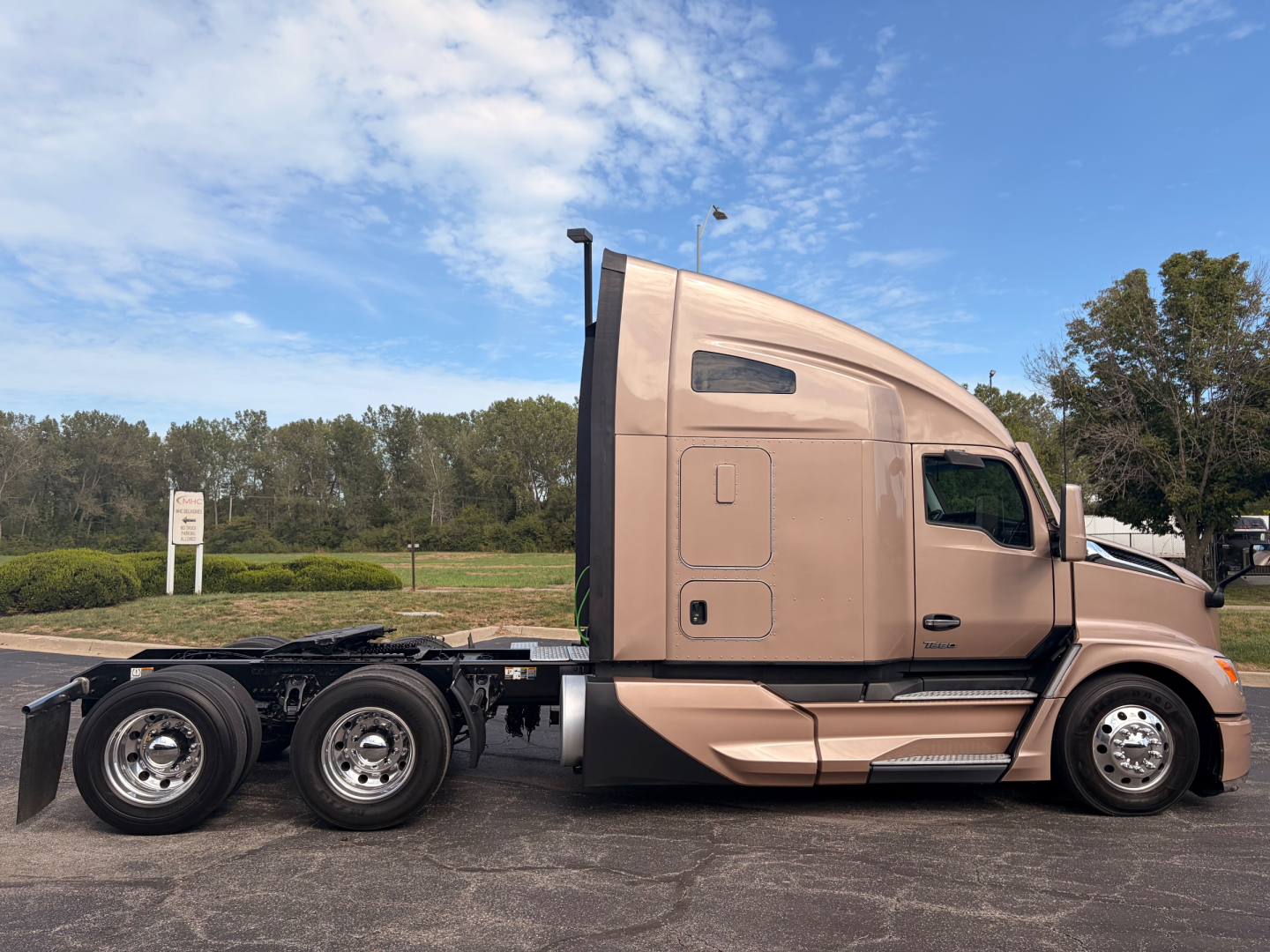Kenworth T680 tractor in profile view showing sleeper cab and chassis with dual rear axles, tan exterior, no trailer, side text not visible.