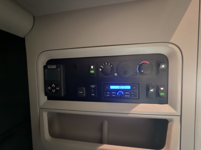 Kenworth T680 cab controls panel and dashboard view showing climate controls and radio in a sleeper truck interior.