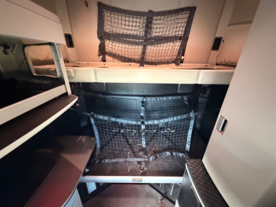 Kenworth T680 interior sleeper cab cargo area with storage shelves, netted cargo barrier, and seating/step area visible.