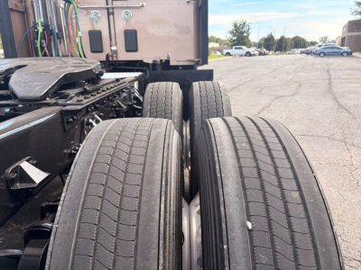 Kenworth T680 truck rear view showing dual rear axles and tires, part of the chassis with cab in background.