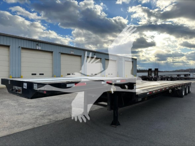 Flatbed trailer with three-axle extendable bed showing DT2000 Transcraft model and VIN and stock plate in front area.