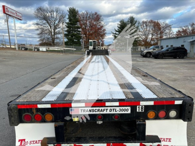 Transcraft DTL-2000 drop deck trailer rear view showing deck planks, taillights, bumper, and Transcraft DTL-3000 sticker.