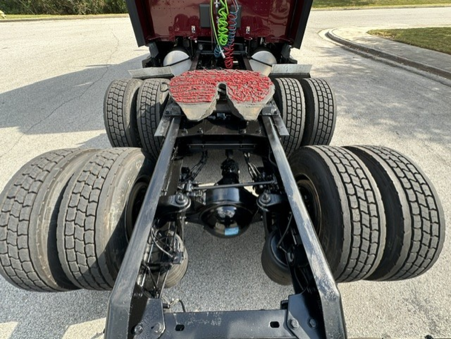 Kenworth T680 chassis rear view showing dual rear axles, fifth-wheel, and suspension components.