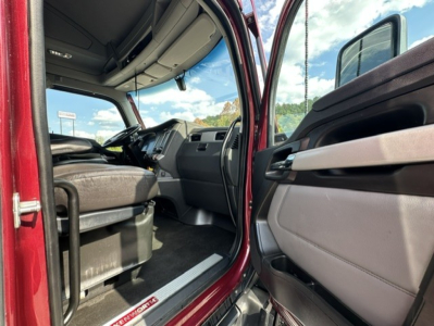 Kenworth T680 cab interior view from open driver door with seating and dashboard visible.