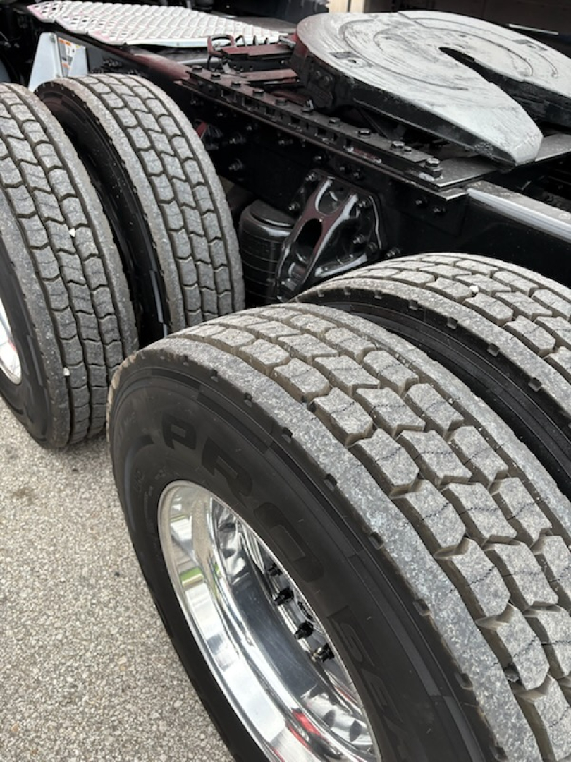 Kenworth T680 rear dual tires and chassis section showing suspension components and fifth wheel area.