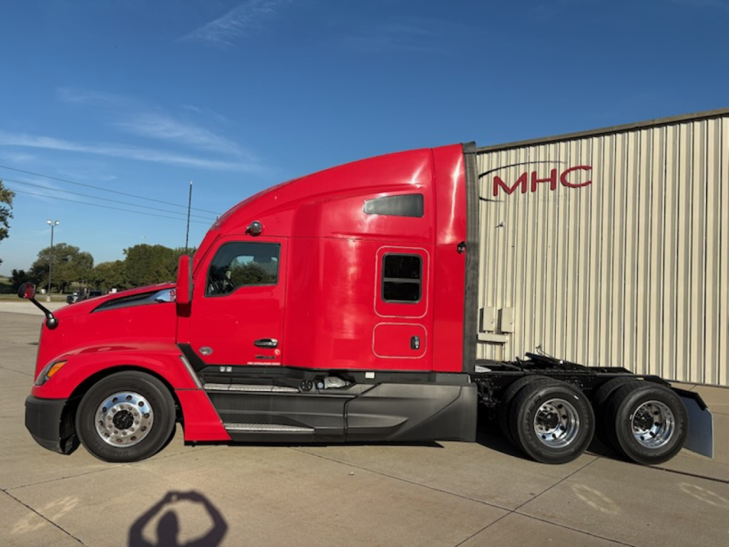 Kenworth T680 tractor in red cab with long black lower guard and attached gray trailer showing MHC logo.