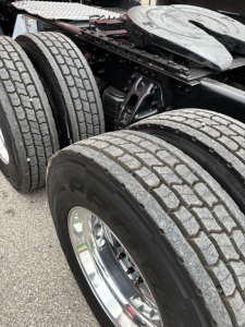 Kenworth T680 rear dual tires and chassis section showing suspension components and fifth wheel area.