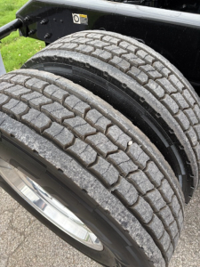 Two rear truck tires with tread pattern and wheel rims on a Kenworth tractor