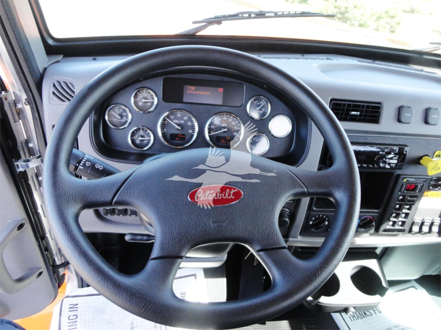Peterbilt dashboard and steering wheel inside cab showing gauges and controls.