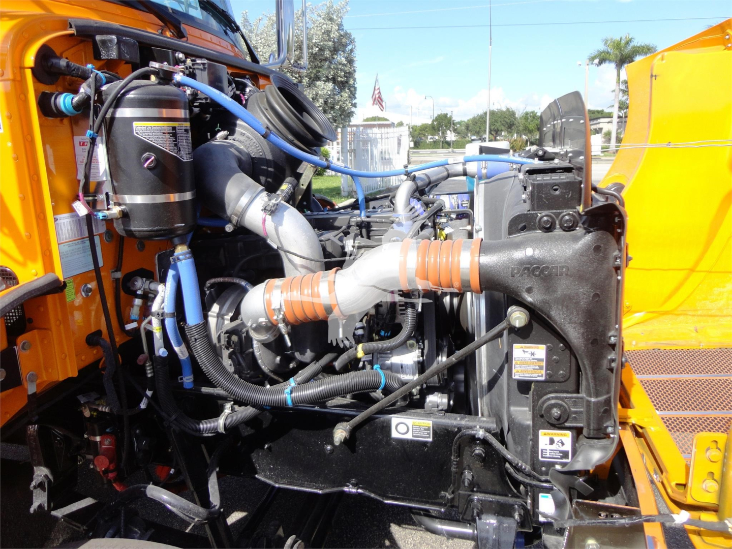 Peterbilt 337 engine bay showing radiator, hoses, coolant reservoir, and turbo with blue silicone hoses.