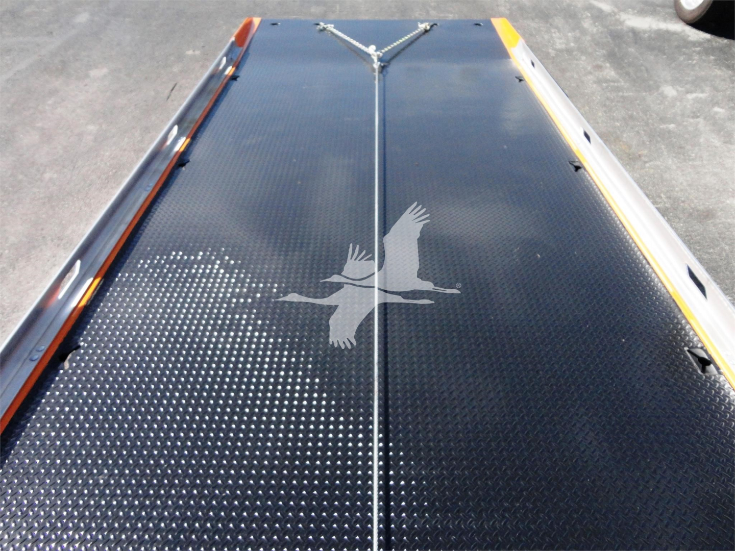Viewing a flatbed surface on a rollback truck with a diamond plate pattern and reflective markings.