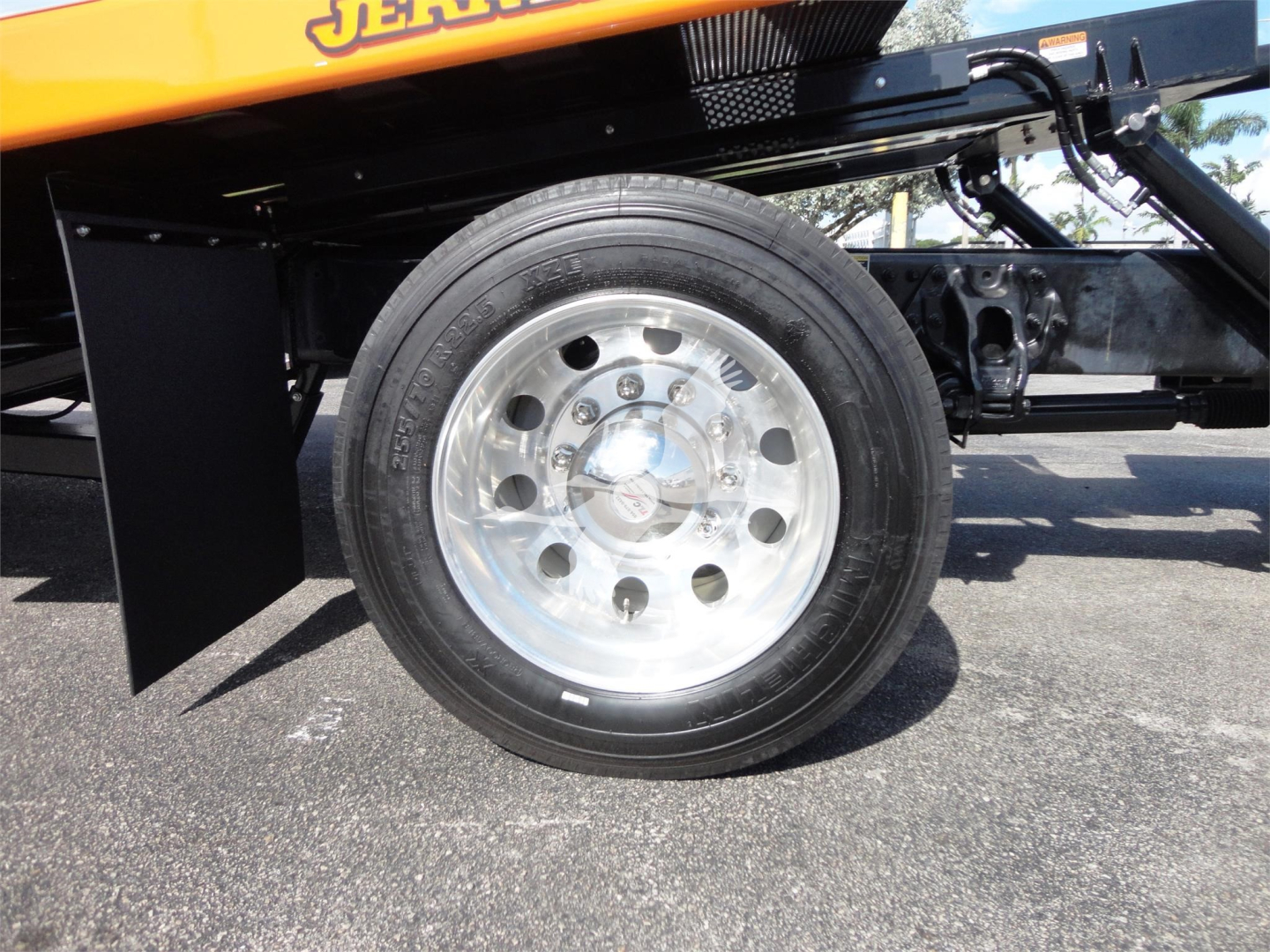 Wheel on Peterbilt 337 rollback truck showing shiny polished steel rim and tire with black fender and undercarriage components.