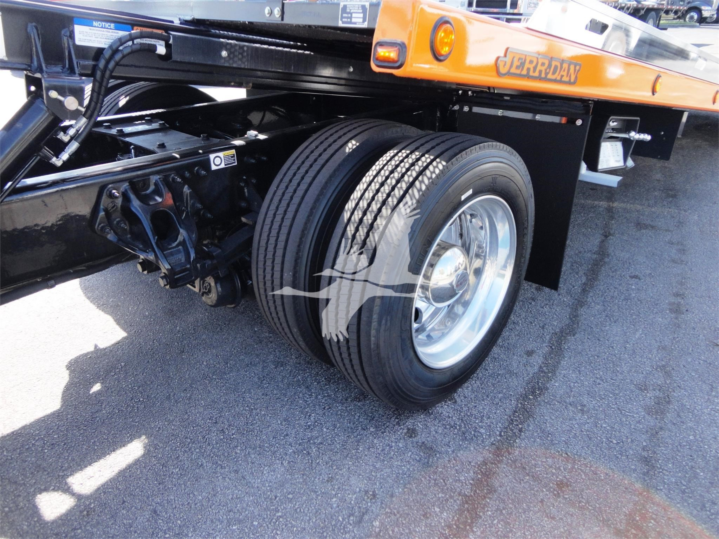 Peterbilt 337 rollback truck rear dual tires and chassis close-up showing wheel assembly and suspension components.