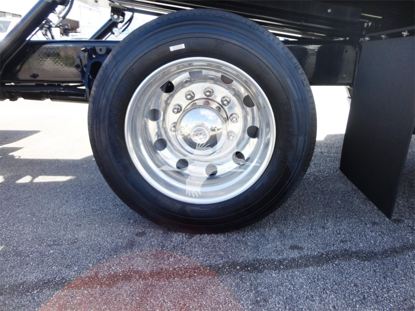 Peterbilt 337 wheel/tire assembly on a rollback truck viewed from side, polished dual rear wheels, chrome hub with bolts.