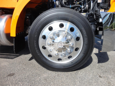 Wheel on a 2022 Peterbilt 337 rollback truck showing chrome hub with multiple lug nuts and black tire.