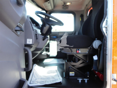 Peterbilt 337 truck cab interior view showing driver seat, steering wheel, pedals, and dashboard from the doorway.