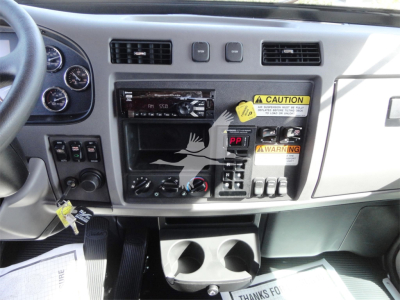 Peterbilt 337 dashboard/center console with cruisem control and gauges, warning labels and cup holders.