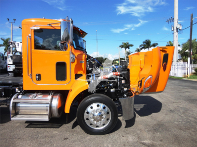 Peterbilt 337 truck in orange with hood open showing engine bay and side steps.