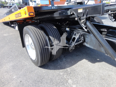 Peterbilt 337 rollback chassis showing dual rear wheels and undercarriage components, with a hydraulic/tilt mechanism and frame rails visible.