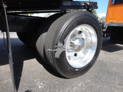 Peterbilt 337 rollback truck front wheel close-up showing dual rear axles and polished aluminum wheel.