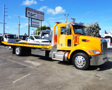 Peterbilt 337 rollback tow truck in yellow with flatbed, side view showing cab and chrome bumper