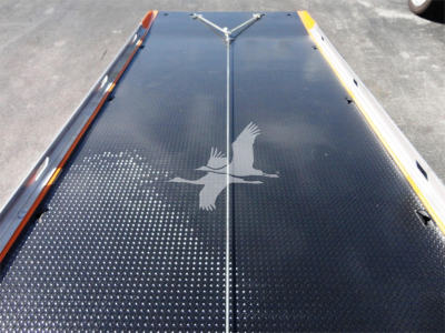 Viewing a flatbed surface on a rollback truck with a diamond plate pattern and reflective markings.