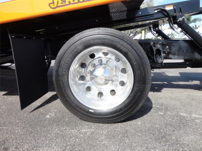Wheel on Peterbilt 337 rollback truck showing shiny polished steel rim and tire with black fender and undercarriage components.