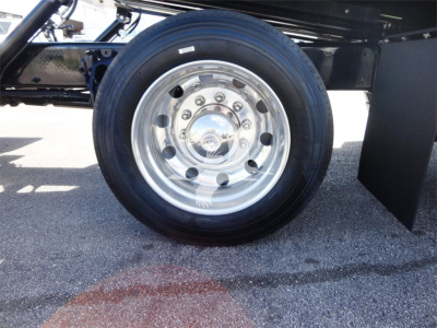 Peterbilt 337 wheel/tire assembly on a rollback truck viewed from side, polished dual rear wheels, chrome hub with bolts.