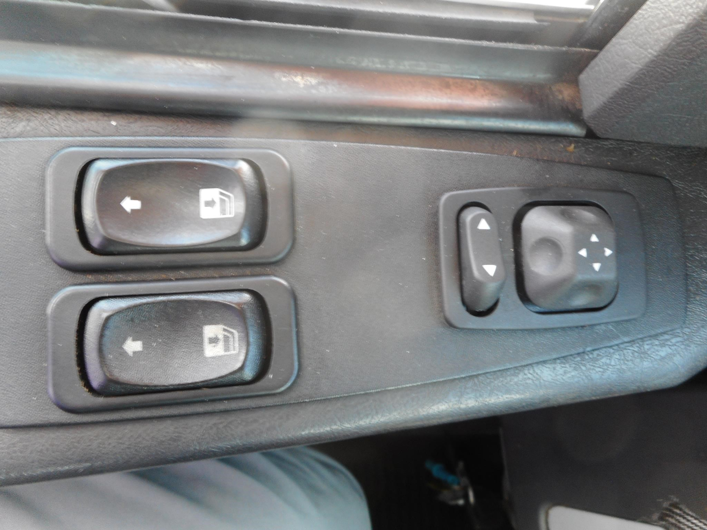 Dashboard window controls on Freightliner 122SD cab showing switch panels for mirrors and window/seat adjustment