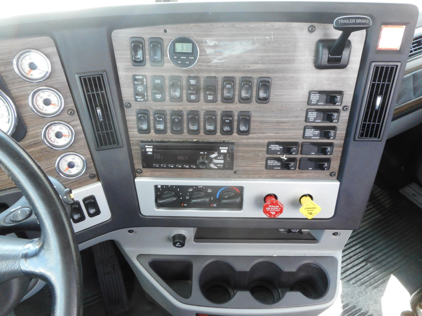 Dashboard of a 2019 Freightliner 122SD showing switches, gauges, and storage compartments in a day cab interior.
