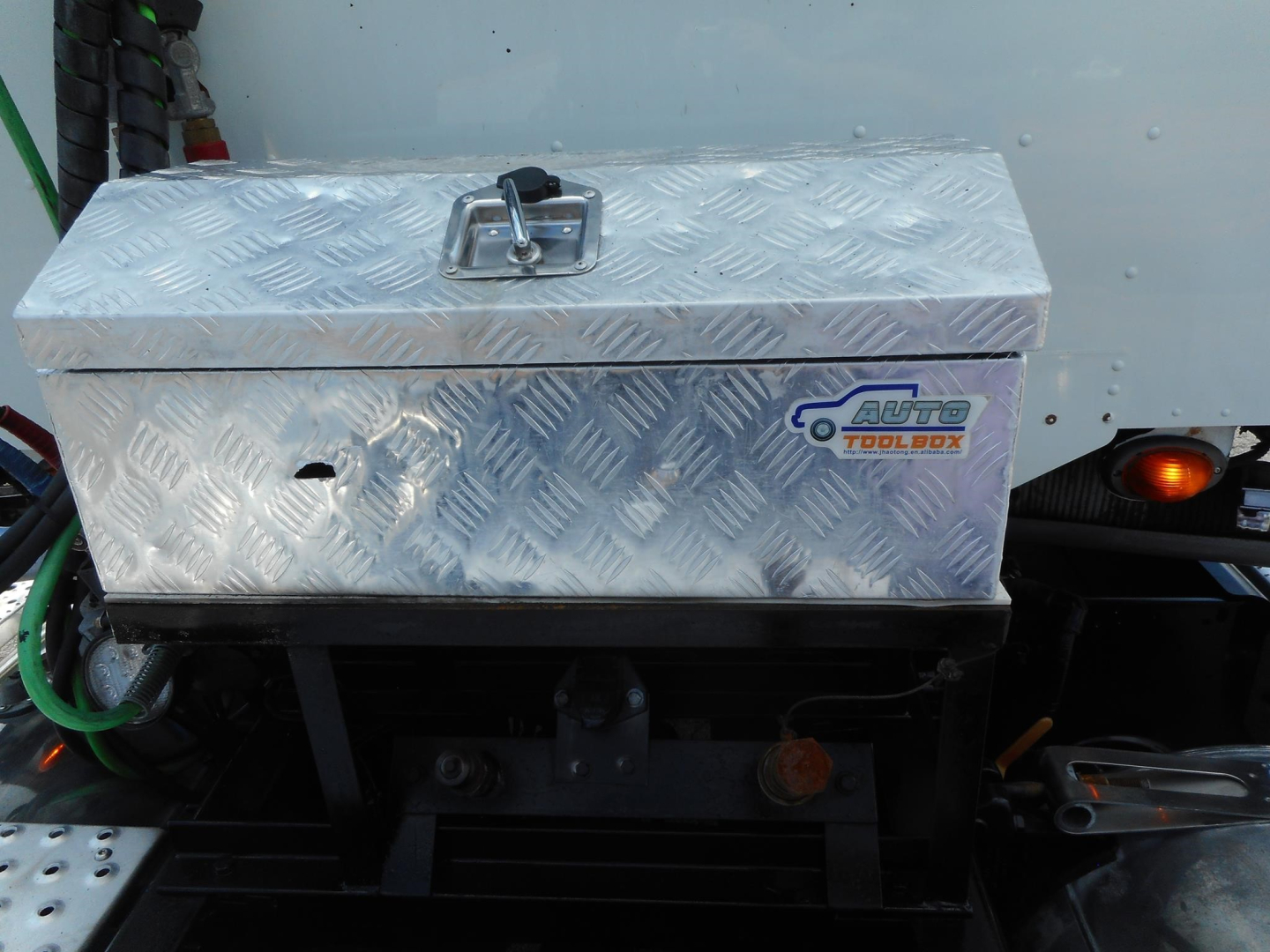 Aluminum diamond-plate tool box on Freightliner 122SD with Auto Tool Box logo visible.