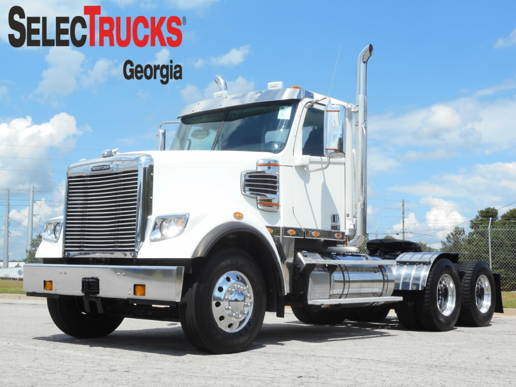 2019 Freightliner 122Sd daytime cab truck with chrome exhaust stack, front grille, and dual rear axles in a lot; SelecTrucks Georgia watermark.