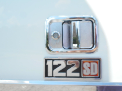 Freightliner 122SD badge and door handle close-up showing 122SD emblem on a white truck