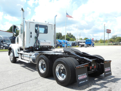 Freightliner 122SD tractor rear view showing dual rear axles and fifth wheel, chrome fuel tanks, exhaust stacks, and rear mud flaps with Fleet branding.