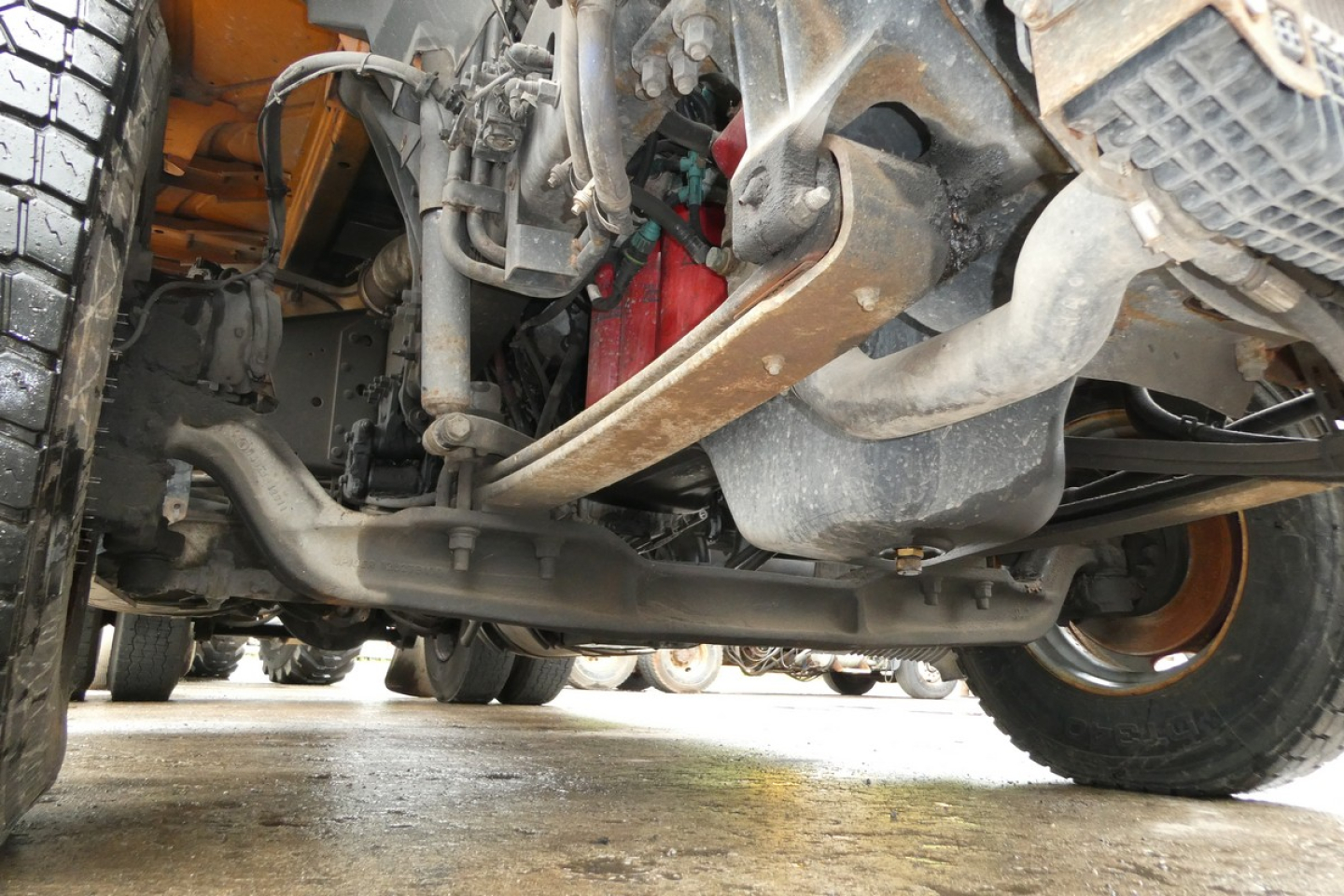 Volvo VNM42T truck undercarriage showing front axle, suspension, steering linkage, and drivetrain components.