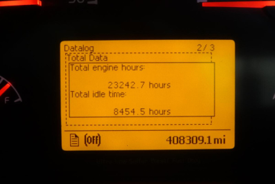 Volvo VNM42T truck instrument display showing total engine hours 23242.7 and total idle time 8454.5 hours, odometer 408309.1 miles.
