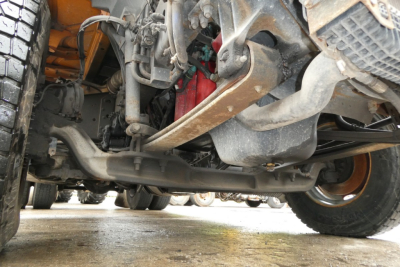 Volvo VNM42T truck undercarriage showing front axle, suspension, steering linkage, and drivetrain components.