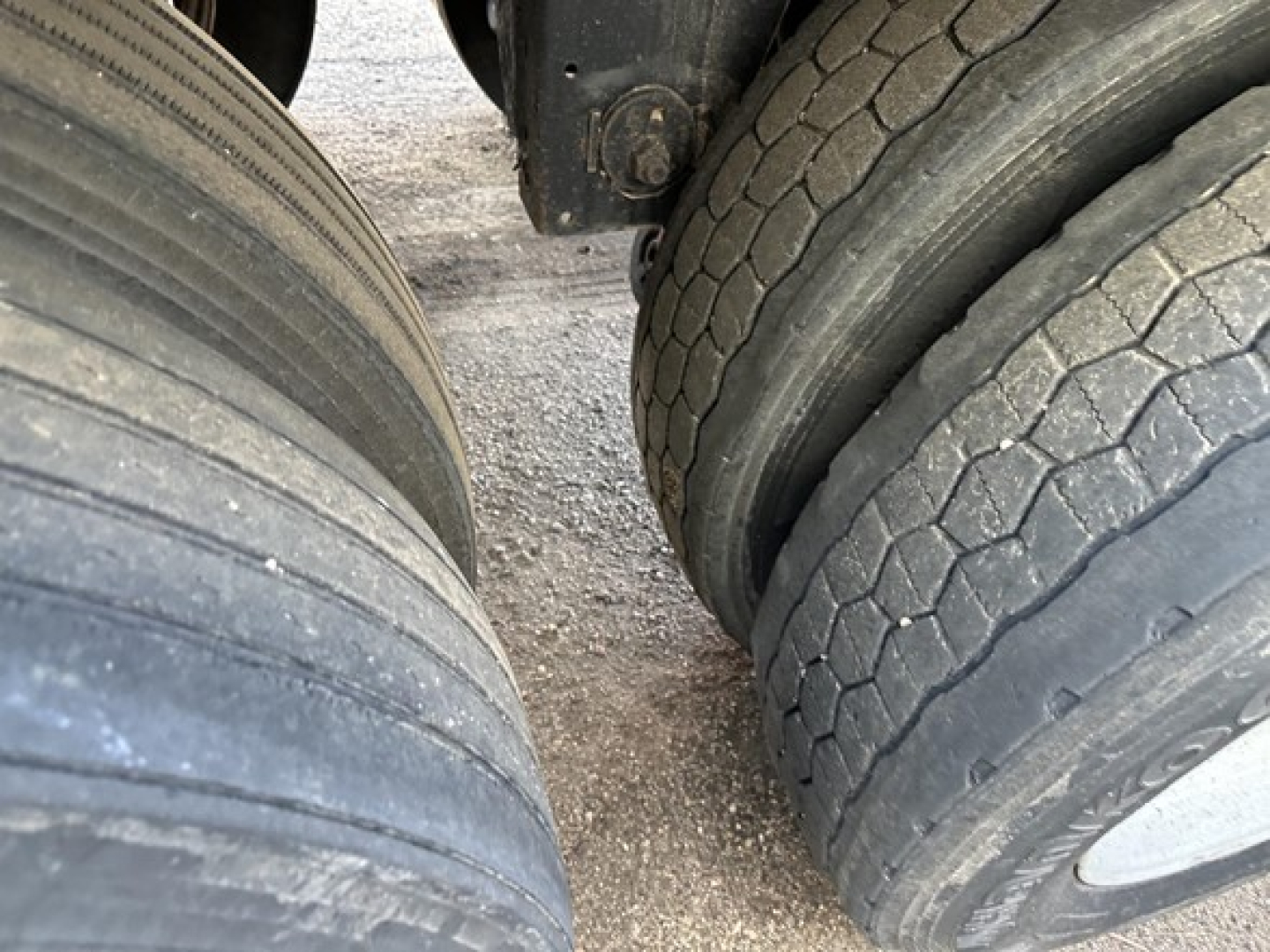 Trailer tires and undercarriage view of a Merritt Heritage hopper trailer, showing dual tires with tread patterns and wheel hubs.