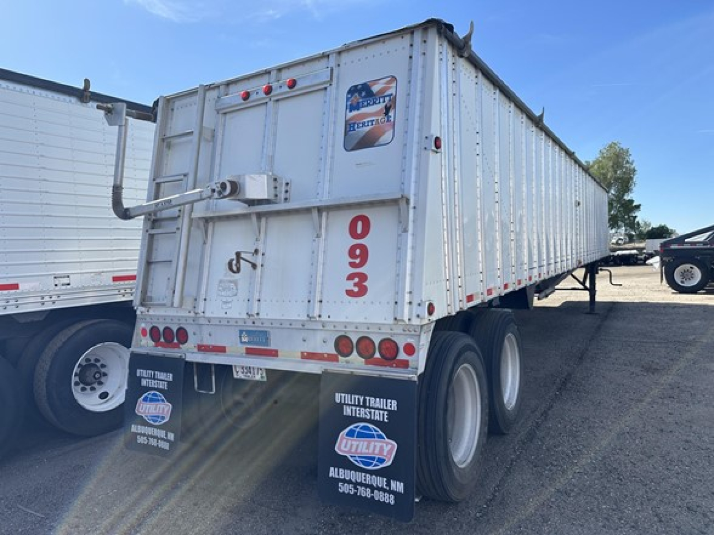 Trailer rear view showing Merritt Heritage hopper trailer with tall vertical '093' markings, two rear axles, and reflective strips.