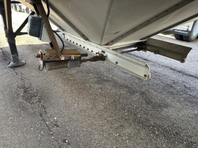 Trailers undercarriage showing hitch and support beams of a Merritt Heritage hopper trailer with a loaded lower platform and torsion bar.