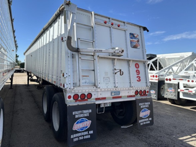 Rear view of a white Merritt Heritage hopper trailer showing rear doors, taillights, and mudflaps with Utility Trailer Interstate branding.