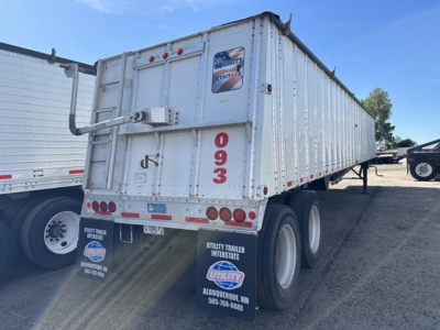 Trailer rear view showing Merritt Heritage hopper trailer with tall vertical '093' markings, two rear axles, and reflective strips.