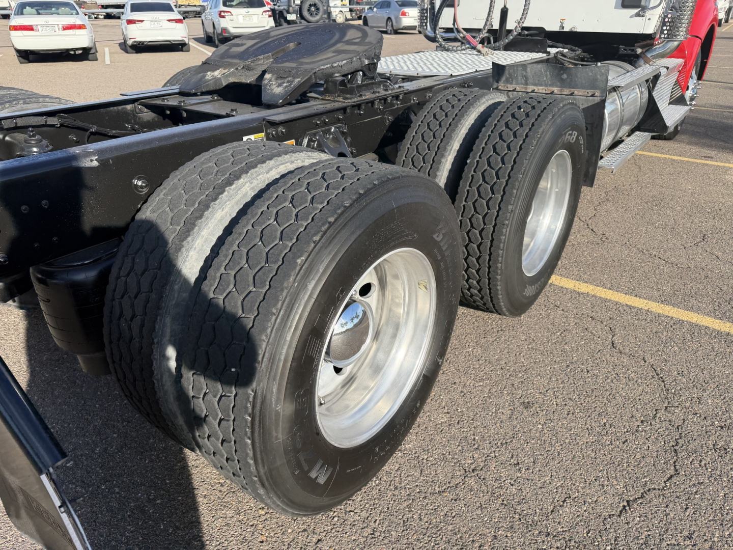 Kenworth T880 chassis showing dual rear axles with heavy-duty tires and wheel rims, fifth wheel and frame rail visible.