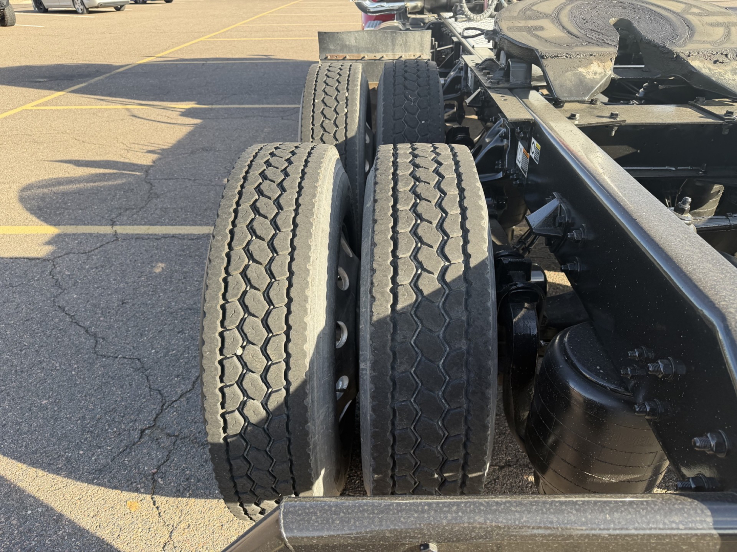 Kenworth T880 chassis showing dual rear axles with tires and suspension components.