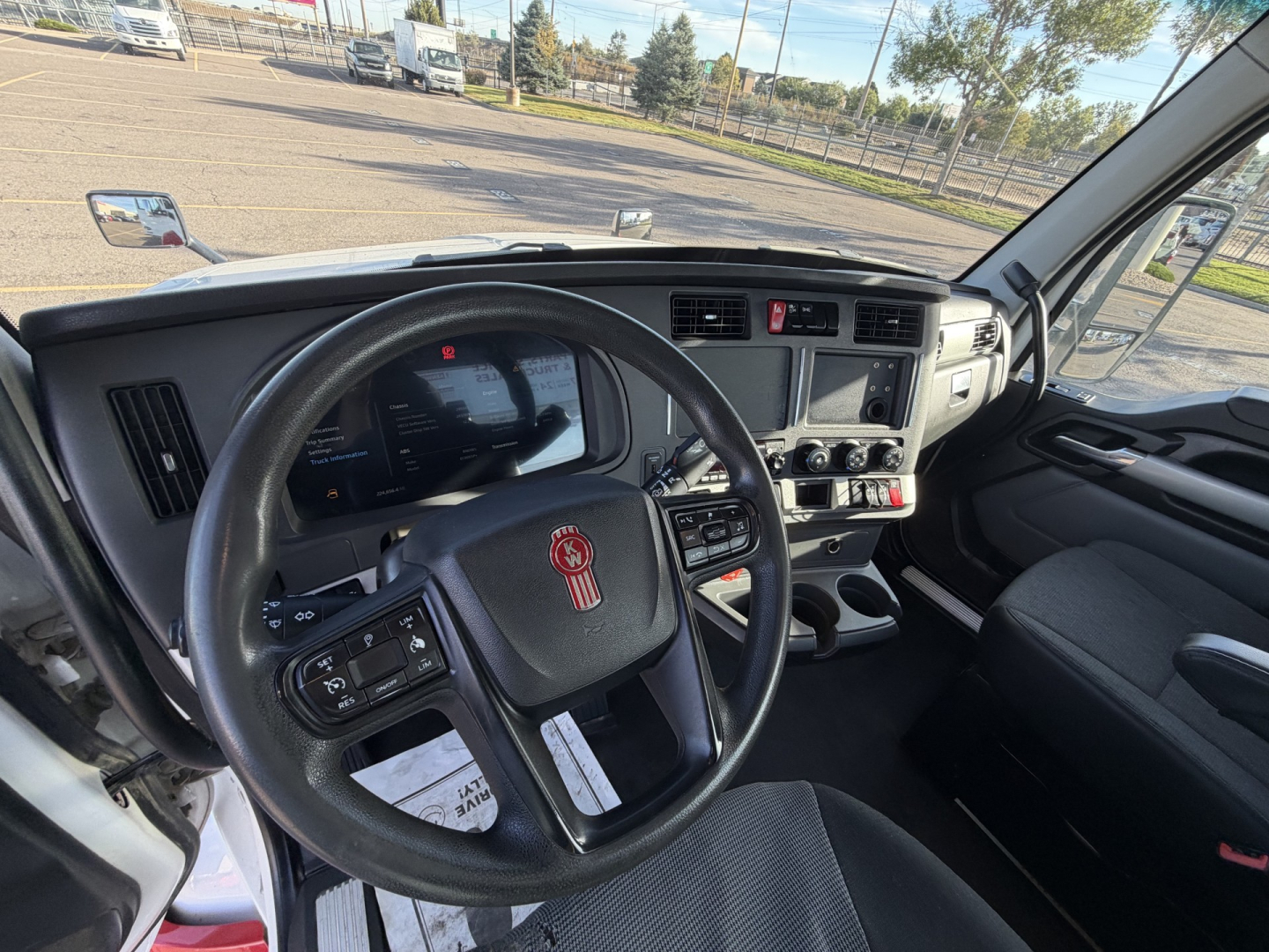 Kenworth T880 truck interior view showing steering wheel and dashboard with infotainment display and controls.