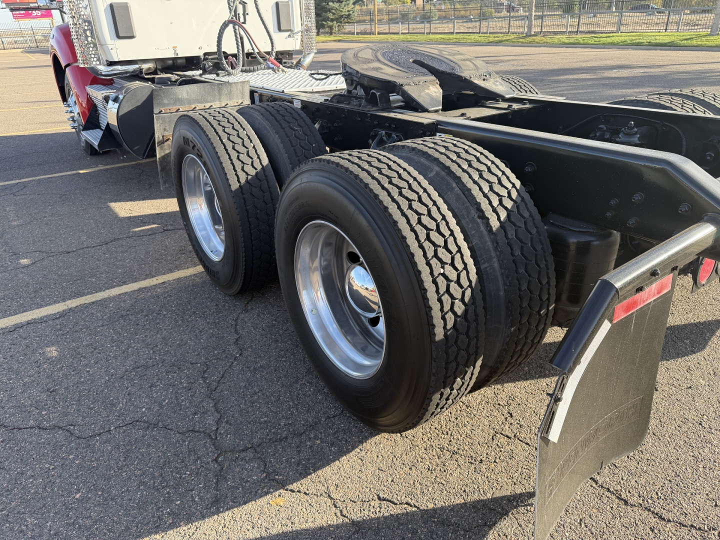 Kenworth T880 rear chassis with dual rear axles and tires showing wheel rims and mud flaps.